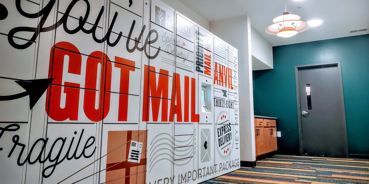 White Parcel Pending by Quadient smart lockers with blue and orange writing on them inside the Anvil 38 Apartments in Lafayette, Indiana