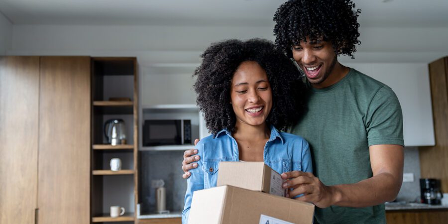 Happy African American couple at home receiving packages in the mail and smiling