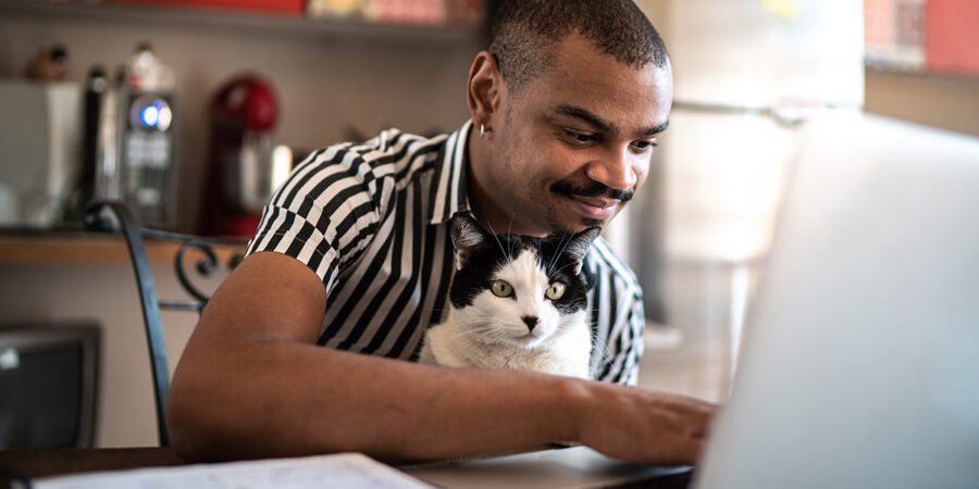 Man shopping online at home with his domestic cat