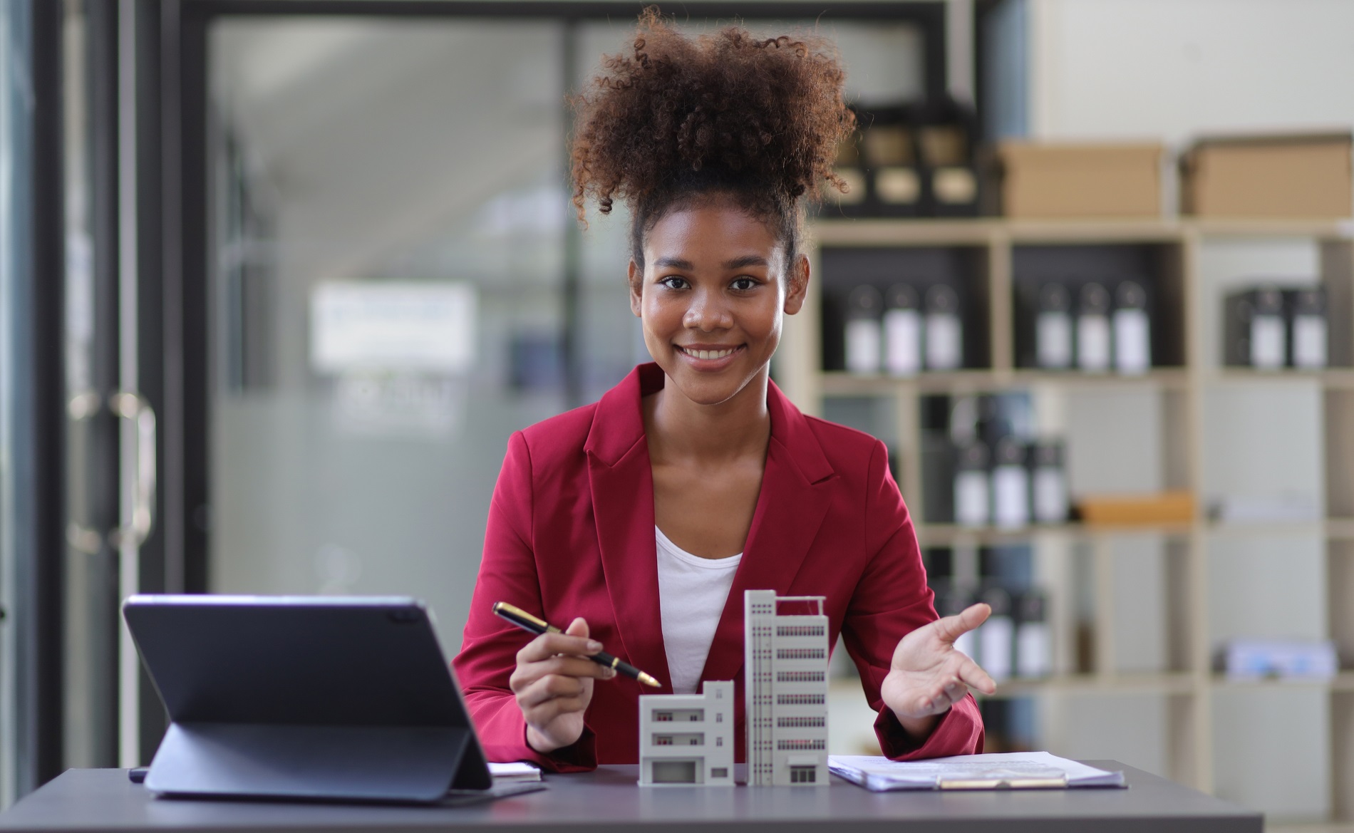 Young property manager with cardboard models of a multifamily building