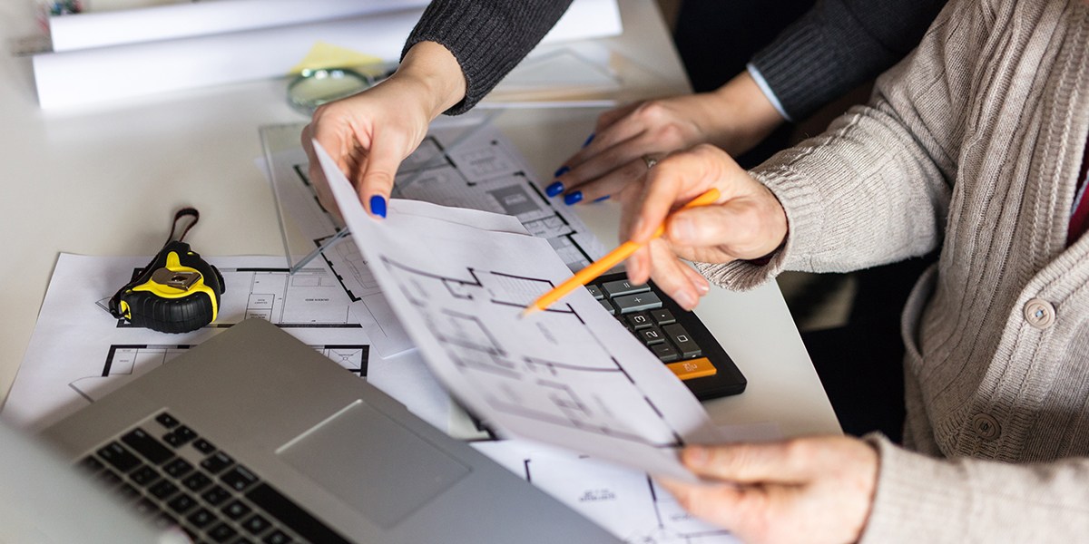 Young property manager consult with his superior on floorplans