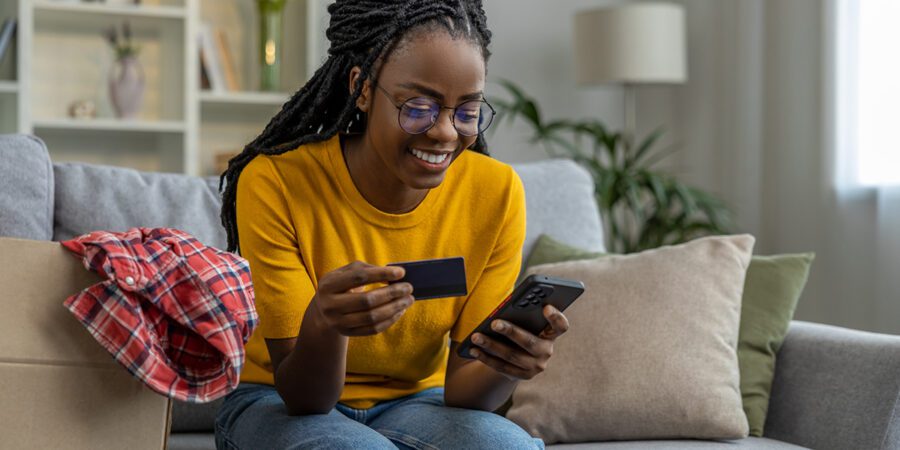 African american young woman buying something online and smiling